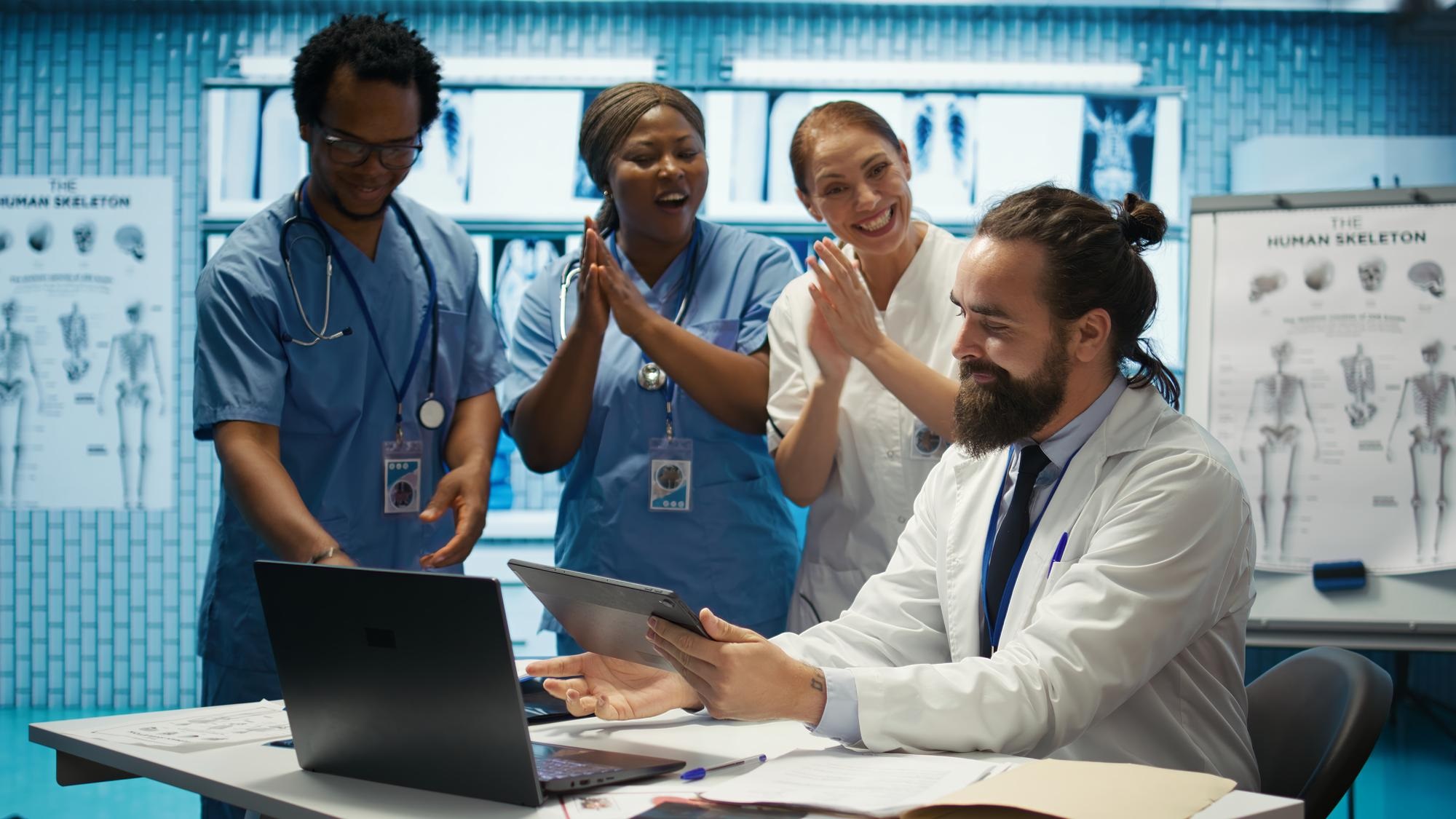 Equipo médico celebrando un mantenimiento exitoso de equipos médicos, demostrando el impacto positivo en la atención al paciente
